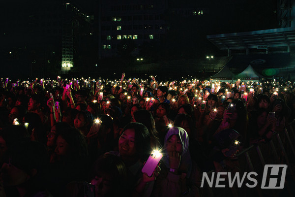 ▲ The crowd lights up the night with phone flashlights. 