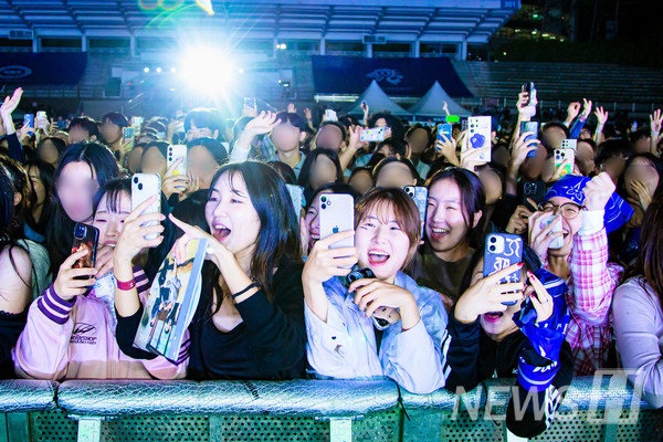 ▲ Fans in the audience cheer and shout in excitement. 