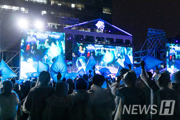 ▲ A moment of unity as the audience waves blue cheering bags and sings along. 