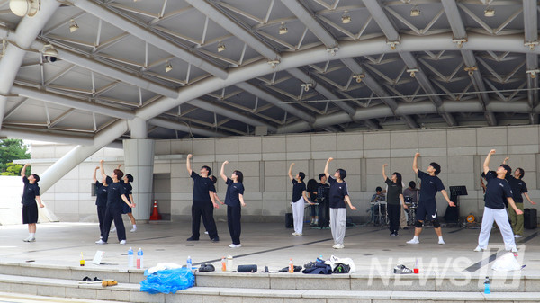 ▲ Members in practice uniforms rehearse performance in unison. 
