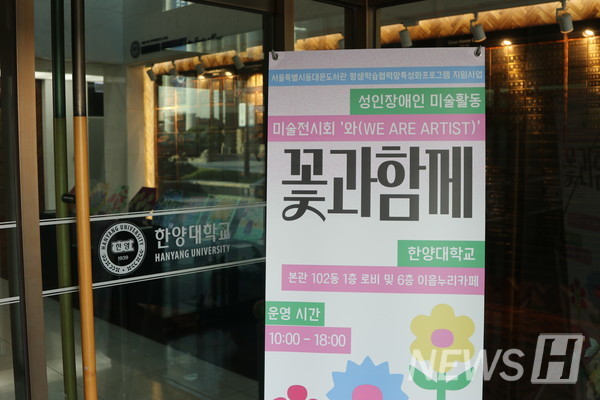 ▲ 서울캠퍼스 신본관 1층 출입문에 서있는 '꽃과 함께' 전시회 현수막의 모습. ⓒ 하지민 기자