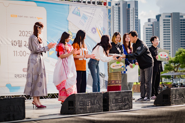 송창근 토토사이트 추천 국제교육원장이 글로벌 부스 운영 학생들에게 우수 운영 부스 상을 수상하고 있다. 이날 학생들이 운영하는 전체 부스가 우수 부스로 선정되었다.