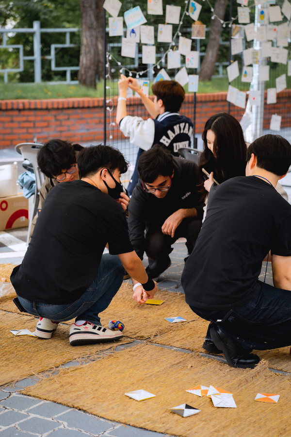 Students are learning traditional Korean game Ddakji-chigi(slap match game).