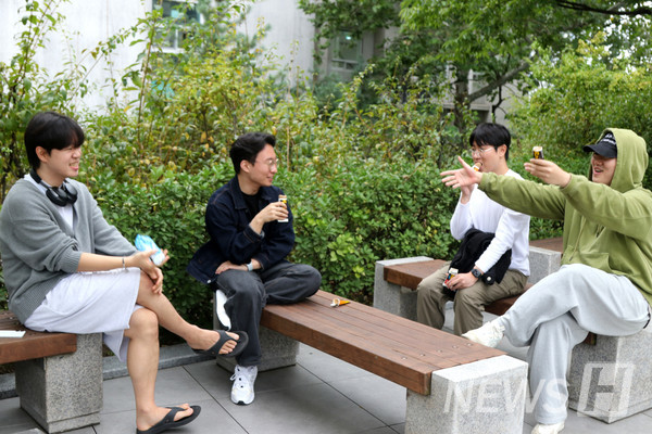 ▲ Students taking a break sharing ice cream on benches in front of the Paiknam Academic Information Center and Library. 