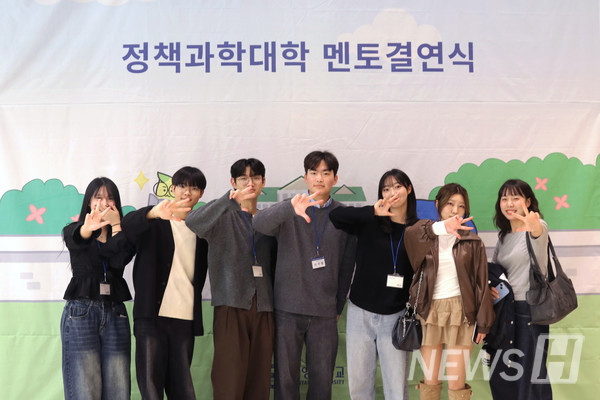 ▲ 멘토결연식 현수막 앞에서 기념사진을 촬영 중인 학생들.