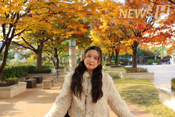 ▲ 알록달록 물든 나무 아래서 한 학생이 가을 단풍을 만끽하고 있다.