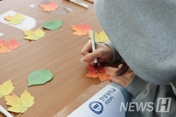▲ 한 학생이 단풍잎 모양 포스트잇에 자신의 성취 경험을 적고 있다.