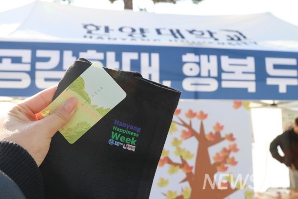 ▲ 행사 참여 경품을 손에 쥔 학생이 부스 앞에서 인증사진을 남긴다.