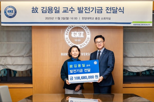 ▲ 故김용일 교수 부인인 박서경 여사가 이기정 총장에게 발전기금을 전달하고 있다