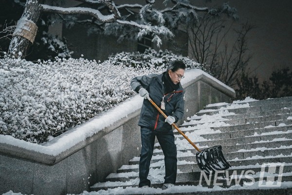 ▲ 시설팀 직원이 계단 위에 쌓인 눈을 치우며 통행로를 정비하고 있다.