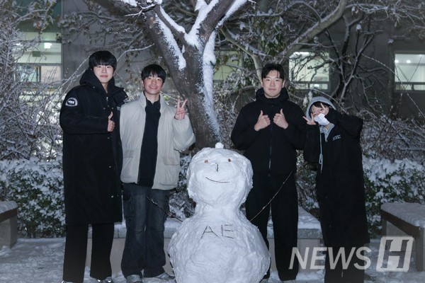 ▲ 学生们在雪人旁摆姿势拍照。