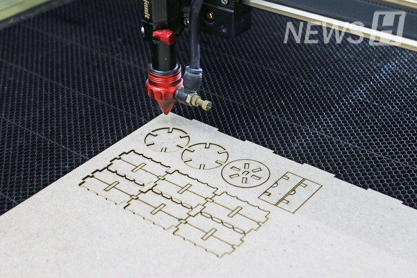 ▲ A laser cutter is precisely cutting MDF plywood from a programmed input. 