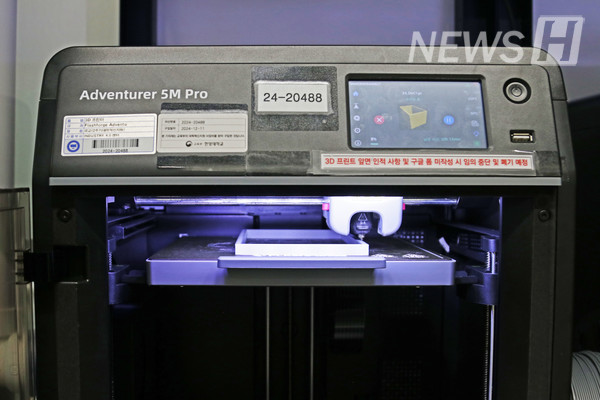▲ A 3D printer in operation. The 3D printer is building a structure by stacking layers one by one. 